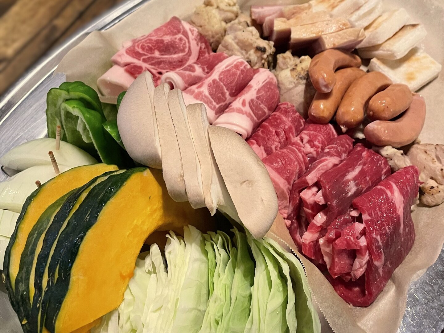 くわるびのBBQプランの食材5名分。肉やウインナー、野菜などが並ぶ盛り合わせ